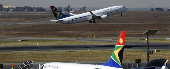 FILE: A South African Airways flight takes off as another one is parked in a bay on the tarmac on 25 May, 2010 at the Johannesburg O.R Tambo International airport in Johannesburg, South Africa. Picture: AFP
