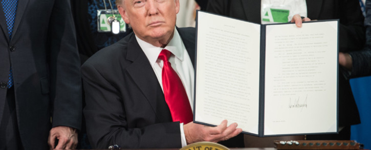 FILE: US President Donald Trump signs an executive order to start the Mexico border wall project at the Department of Homeland Security facility in Washington on 25 January 2017. Picture: AFP.

