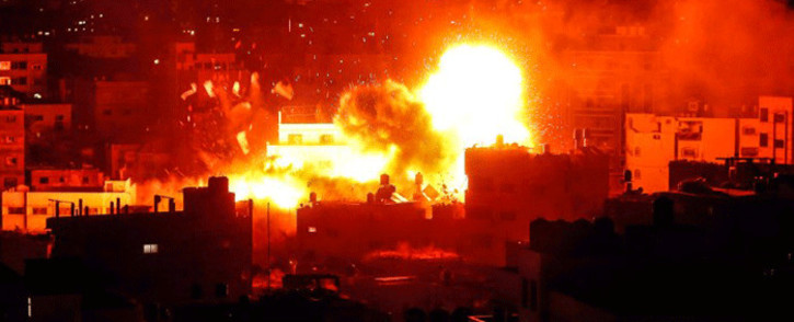 A picture taken on 12 November, 2018, shows a ball of fire above the building housing the Hamas-run television station al-Aqsa TV in the Gaza Strip during an Israeli air strike. Picture: AFP