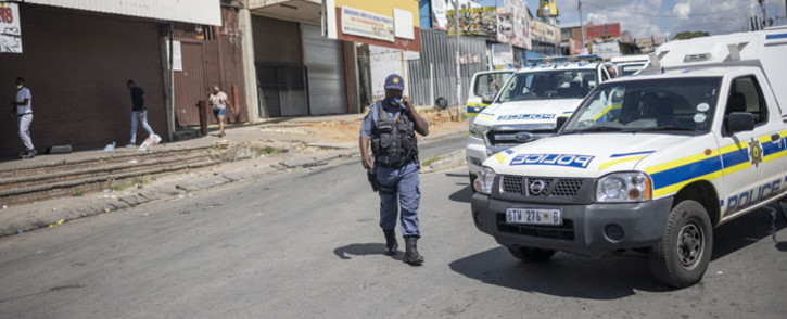 A member of the South African Police Service (SAPS) walks toward his vehicle during a demonstration of the anti-migrants movement called "Operation Dudula" in Alexandra township, on 7 March 2022. Picture: Michele Spatari/AFP