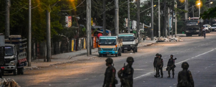 FILE: Soldiers keep watch as they block an empty street in Yangon on 10 March 2021, as security forces continue to crackdown on demonstrations by protesters against the military coup. Picture: AFP