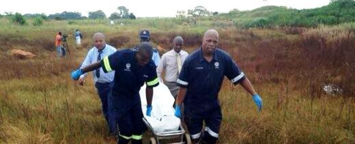 Forensic pathologists carry the body of one of the girls found dead in Dobsonville, Soweto, on 19 February 2014. Picture: Masego Rahlaga/EWN.