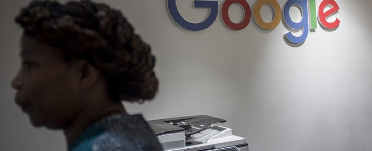 A worker of the Google Artificial Intelligence (AI) centre walks through a Google sign inside the office in Accra on 10 April 2019. This centre is the first AI centre established in Africa by Google. Picture: AFP