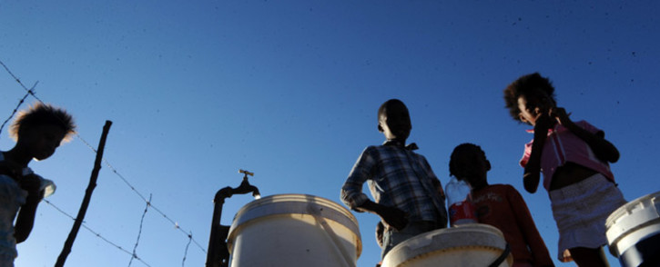 Youths fill their buckets with water from a tap after water supply was restored in Boitumelong Township in Bloemhof, North West on 29 May 2014. Picture: Sapa.