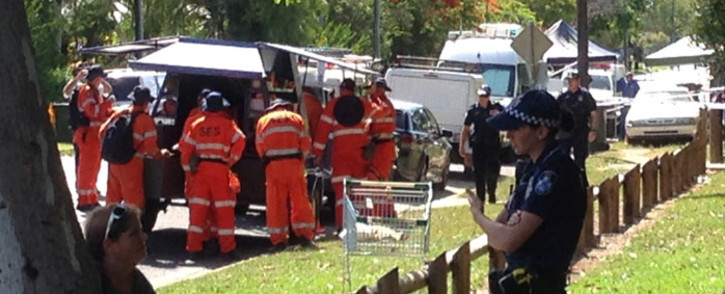 This photo shows the police (R) at the scene outside a house where eight children ranging from babies to teenagers were found dead in the northern Australian city of Cairns on 19 December, 2014. Picture: AFP.