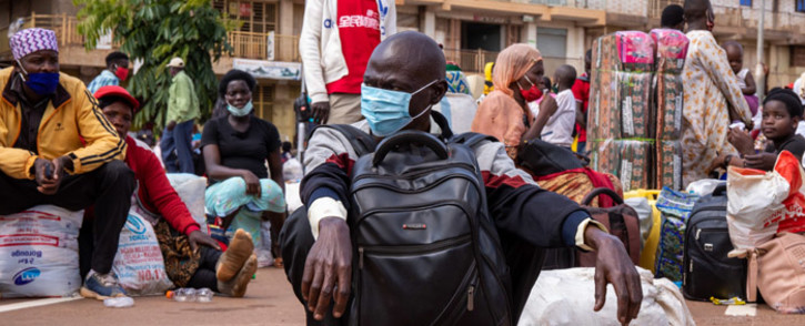 FILE: A traveller wears a face mask, as a preventive measure against the spread of the COVID-19 coronavirus, while he waits for an intercity bus at the Namirembe Bus Park in Kampala, Uganda, on 4 June 2020, the first day of re-opening public transport. Picture: AFP.