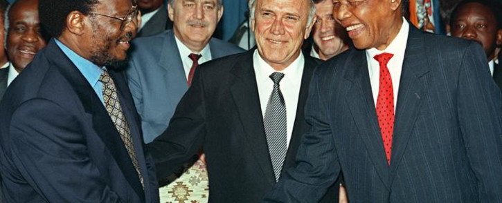 FILE: South African President Frederik W. De Klerk (centre) smiles while ANC leader Nelson Mandela (right) and IFP leader Mangosuthu Buthelezi shake hands after they signed an agreement at the Union Buildings in Pretoria 19 April 1994. Pik Botha, South African Foreign Affairs Minister (C, 2nd row) looks on. Picture: AFP.