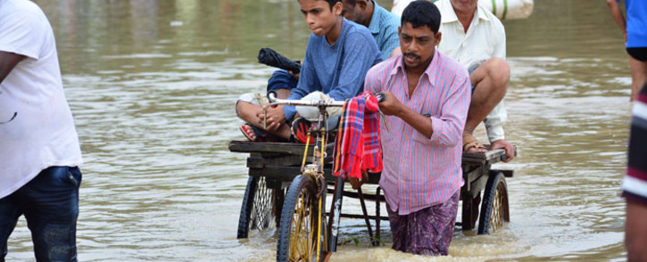 An Indian rickshaw puller transports commuters on a flooded street after a heavy downpour at Baldakhal village in Agartala, the capital of northeastern state of Tripura, on 14 July 2019. Picture: AFP