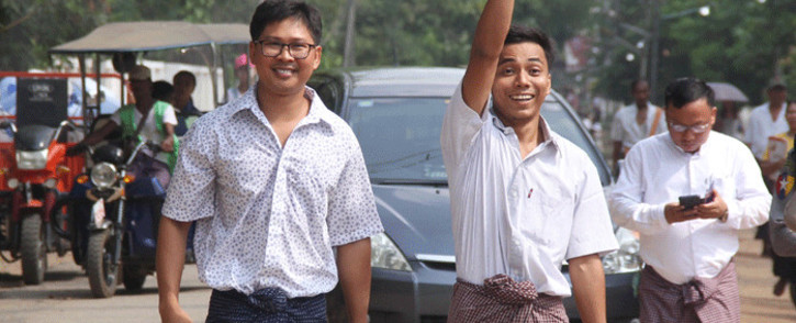 Reuters journalists Kyaw Soe Oo (C) waves beside colleague Wa Lone (L) as they walk out of Insein prison after being freed in a presidential amnesty in Yangon on 7 May 2019. Picture: AFP.