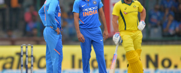FILE: India's Virat Kohli (L) stands with bowler Bhuvneshwar Kumar (C) during the fifth one-day international (ODI) cricket match between India and Australia at the Feroz Shah Kotla Stadium in New Delhi on 13 March 2019. Picture: AFP