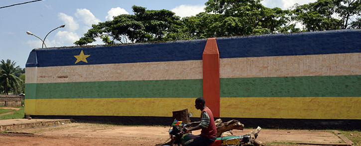 FILE: A man rides a motorbike in front of the jail of Bangui, "Maison Centrale de Ngaragba", whose walls are painted with the colors of the flag of Central African Republic. Picture: AFP
