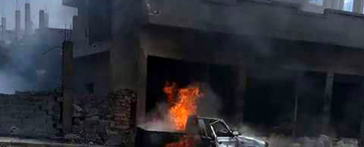 FILE: A handout image released by the official Syrian Arab News Agency on 5 May, 2016 shows a car burning at the site of a bomb attack in Mukharram al-Fawqani in Homs province. Picture: AFP.