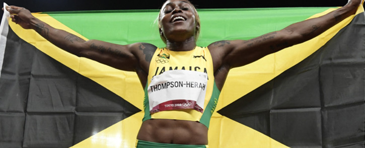 Jamaica's Elaine Thompson-Herah celebrates with the flag of Jamaica after winning the women's 100m final during the Tokyo 2020 Olympic Games at the Olympic Stadium in Tokyo on July 31, 2021. Piture: Javier SORIANO / AFP