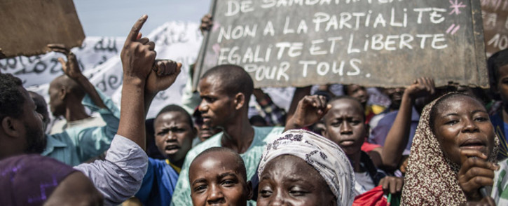 A protester holds a placard reading "No to the injustice of Samba Panza, No to partiality, Equality and freedom for all" as residents demonstrate in the 'Muslim enclave' of the PK5 district in Bangui to express their anger on 31 May, 2014. Picture: AFP. 
