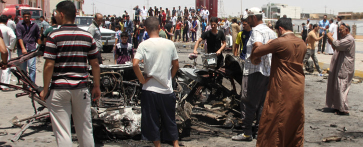 FILE:Iraqis inspect the site of a suicide car bomb attack in the Al-Haq square in Samarra, a predominantly Sunni town north of Baghdad, on 5 July, 2013. Picture: AFP. 