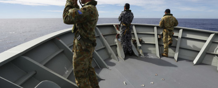 FILE: Australian Defence shows Gunner Richard Brown (L) of Transit Security Element on the lookout on the forecastle of HMAS Perth in the search for missing Malaysia Airlines flight MH370 in the southern Indian Ocean on 9 April 2014. Picture: AFP.