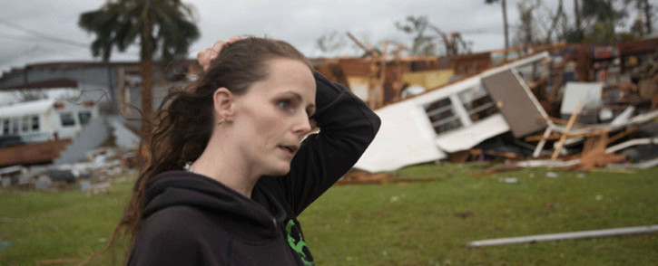 FILE: Haley Nelson stands in front of what is left of one of her father’s trailer homes after hurricane Michael passed through the area on 10 October 2018 in Panama City, Florida. Picture: AFP.