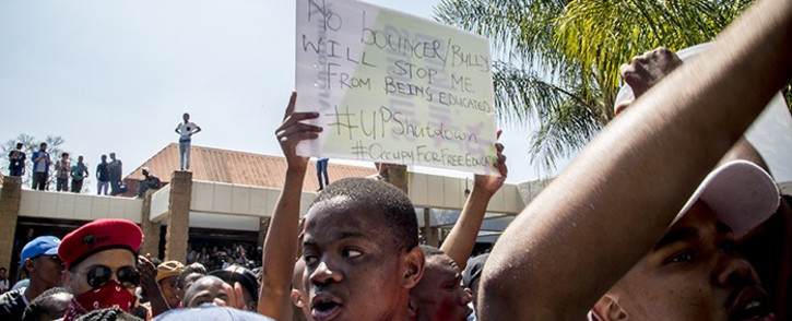 A University of Pretoria student holds up a placard during protests on the institution’s Hatfield campus over possible university fee hikes for the 2017 academic year. Picture: Reinart Toerien/EWN.