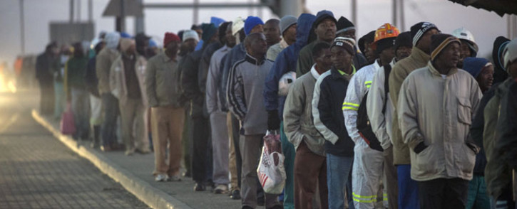 South African platinum miners queue to undergo essential medical and safety procedures before working, early on 25 June 2014 at the Wonderkop mines in Marikana Rustenburg, after a five month long strike. Picture: AFP.