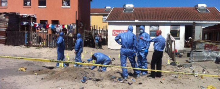 Police forensic experts in Hazmat suits digging a deep hole behind the homes of two missing Mitchells Plain girls. Picture:EWN