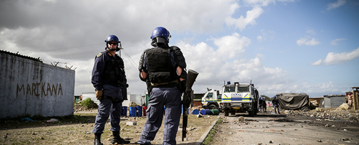Law enforcement officials keep a watchful eye over vacant land in Philippi East following violent evictions in the area last week. Picture: EWN