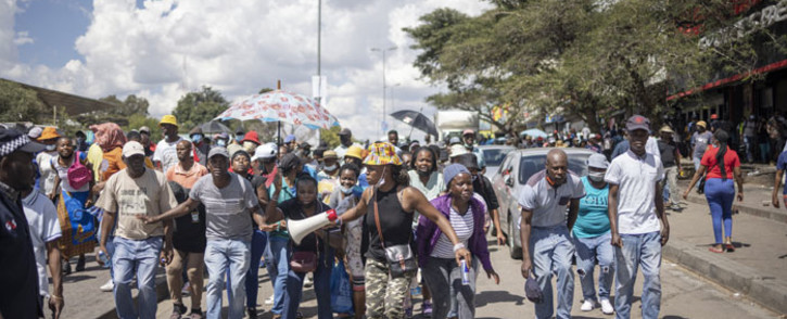 Disgruntled South African job seekers belonging to the so-called "Operation Dudula" movement sing slogans and dance while marching through Alexandra township, on 7 March 2022. Picture: Michele Spatari/AFP