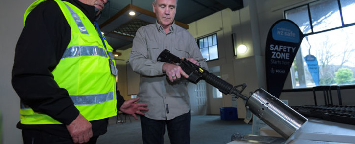 This photo taken on 4 July 2019 shows New Zealand police officers handling a gun example at a press preview ahead of a gun buyback scheme at the Trentham racecourse in Upper Hutt, near Wellington. Picture: AFP
