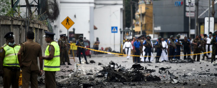 Sri Lankan security personnel inspect the debris of a car after it explodes when police tried to defuse a bomb near St Anthony's Shrine in Colombo on 22 April 2019, a day after the series of bomb blasts targeting churches and luxury hotels in Sri Lanka. Picture: AFP