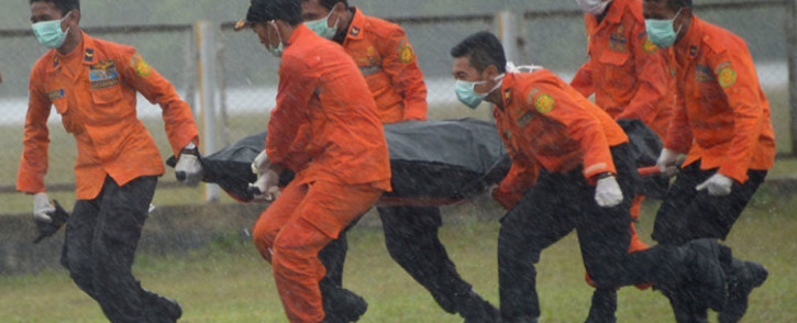 Members of an Indonesian search and rescue team transport the body of a victim from AirAsia flight QZ8501 recovered from the Java Sea in the rain at Pangkalan Bun in Central Kalimantan on 1 January, 2015. Picture: AFP.