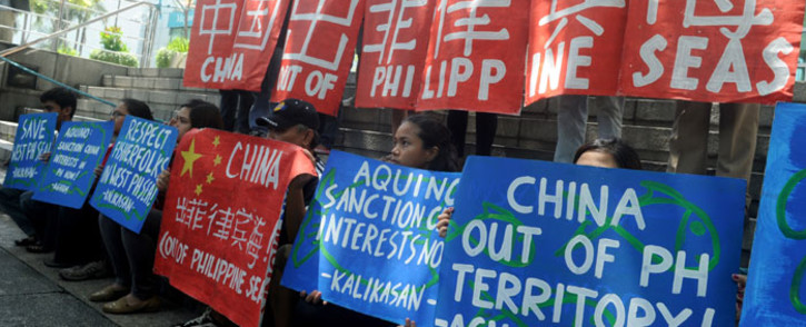 FILE: Filipino environmental activists display placards during a rally outside China's consular office in Manila on 11 May 2015, against China's reclamation and construction activities on islands and reefs in the Spratly Group of the South China Sea that are also claimed by the Philippines. Picture: AFP/Jay Directo.