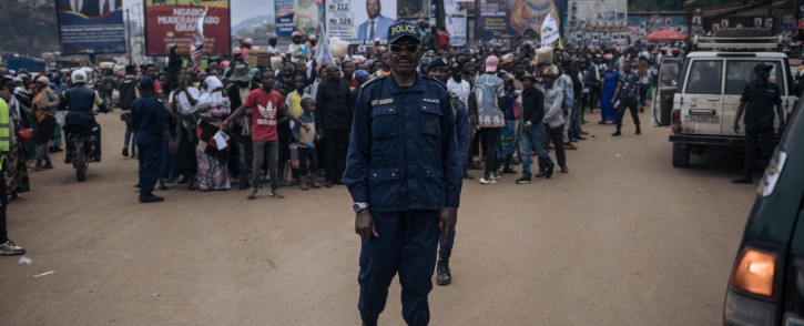 A police officer poses next to supporters of Congolese doctor and presidential candidate Denis Mukwege during a campaign rally in Bukavu, capital of South Kivu province, eastern Democratic Republic of Congo, on 25 November 25. Picture: AFP