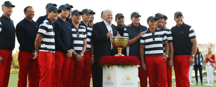 FILE: US President Donald Trump poses with the US Team and the trophy after they defeated the International Team 19 to 11 in the Presidents Cup at Liberty National Golf Club on 1 October, 2017 in Jersey City, New Jersey. Picture: AFP