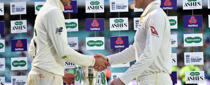 FILE: England's captain Joe Root (L) and Australia's captain Tim Paine shake hands alongside the Ashes trophy during the presentation ceremony on the fourth day of the fifth Ashes cricket Test match between England and Australia at The Oval in London on 15 September 2019. England won the fifth test by 135 runs and drew the series but Australia keeps The Ashes trophy. Picture: AFP