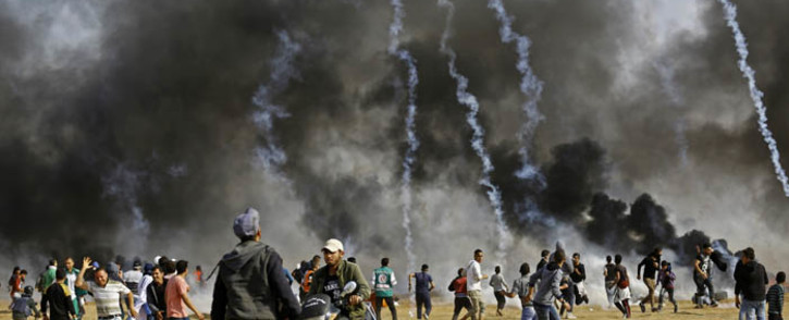 Palestinian demonstrators run to take cover from tear gas as they protest on the Israel-Gaza border, east of the northern town of Jabalia, on 27 April 2018. Picture: AFP.