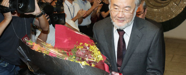 Yoshinori Ohsumi receives a bouquet of flowers at the Tokyo Institute of Technology in Tokyo on October 3, 2016 after winning the Nobel Prize in Medicine. Picture: AFP