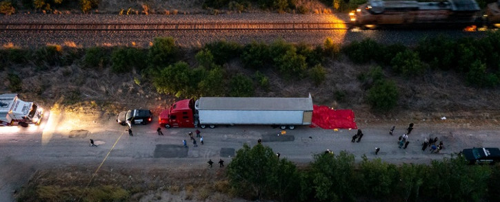 In this aerial view, members of law enforcement investigate a tractor trailer on June 27, 2022 in San Antonio, Texas. According to reports, at least 46 people, who are believed migrant workers from Mexico, were found dead in an abandoned tractor trailer. Picture: Jordan Vonderhaar/Getty Images/AFP