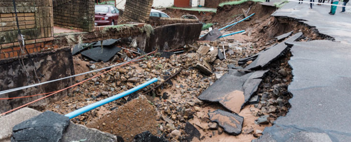 A general view of a severely damaged home and a crack in the road following heavy rains and winds in Durban, on 12 April 2022. Picture: RAJESH JANTILAL/AFP