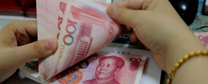 FILE. A teller counts yuan banknotes in a bank in Lianyungang, east China’s Jiangsu province. Picture: AFP.