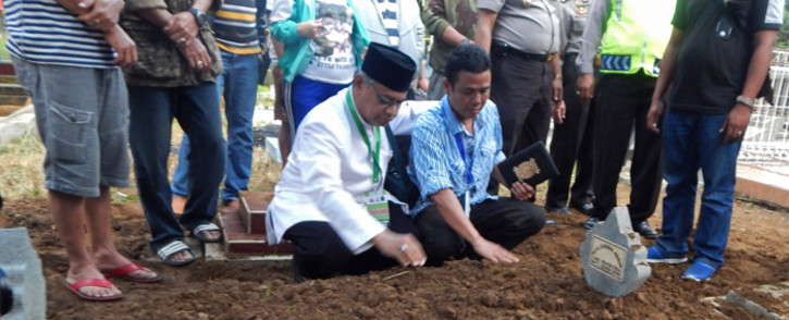 An Islamic cleric (L) prays with Iwan Setiawan (R), brother of executed Indonesian drug convict Zainal Abidin following his burial at a cemetery in Cilacap on 29 April, 2015. Eight drug convicts including two Australians Andrew Chan and Myuran Sukumaran were executed by firing squad on 29 April on the high-security prison island of Nusakambangan in central Indonesia, but a Filipina was spared at the 11th hour. Picture: AFP.
