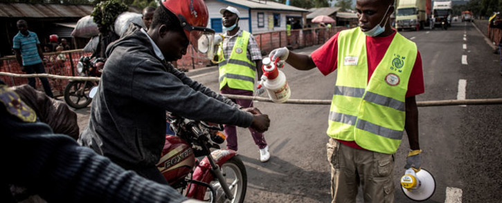 FILE: A motor taxi driver gets his hands washed at an Ebola screening station on the road between Butembo and Goma on 16 July 2019 in Goma. Picture: AFP
