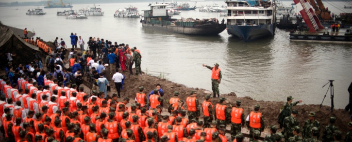 FILE: Chinese soldiers and rescue workers pay their respect to the victims during a memorial service in front of the raised Chinese cruise ship, in Jianli on 7 June, 2015. Picture: AFP.
