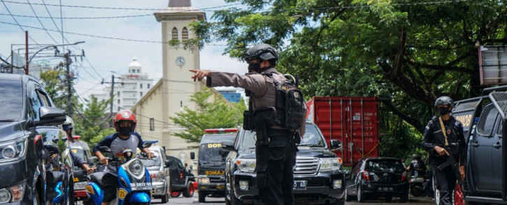 An Indonesian policeman manages the traffic after an explosion outside a church in Makassar on 28 March 2021. Picture: AFP