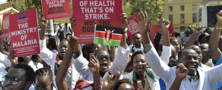 FILE: Kenyan doctors shout slogans and hold placards outside a Nairobi court on 26 January 2017 as they awaited for their union officials to come out. Picture: AFP.