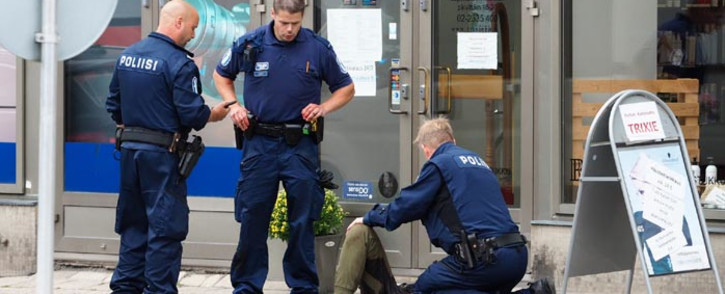 Police officers stand next to a person lying on the pavement in the Finnish city of Turku where several people were stabbed on August 18, 2017. Several people were stabbed in the southwestern Finnish city of Turku, police said after shooting and arresting a suspect. Public television station Yle reported that central Turku was on lockdown, with witnesses saying they had seen bodies lying on the ground in a busy area of the town. Businesses were shut.
Kirsi Kanerva / AFP