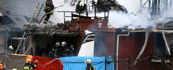 Picture released by Aton Chile showing firefighters working at the scene after a light aircraft crashed into a house in Puerto Montt after taking off from La Paloma aerodrome, about 1000 km south of Santiago on 16 April 2019. Picture: AFP