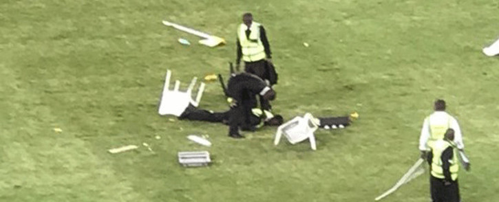 A security guard lies motionless on the ground after being attacked by angry Kaizer Chiefs fans after they invaded the pitch during the Nedbank Cup match against Free State Stars at Moses Mabhida on 21 April 2018. Picture: Screengrab