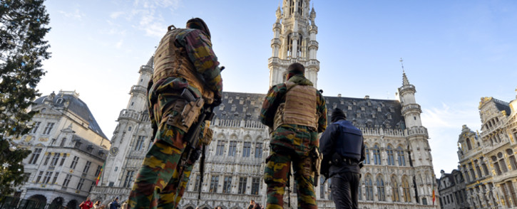 Soldiers and police patrol on Brussels' Grand Place as the Belgian capital remains on the highest possible alert level on November 23, 2015. Belgian police arrested five more people in a new series of anti-terrorism raids Monday, prosecutors said, as the capital Brussels was locked down for a third day under a state of maximum alert. Picture: AFP.