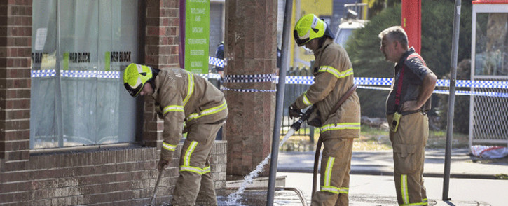 Firemen wash away bloodstains after a security guard was shot dead with another man fighting for his life after a drive-by shooting outside a popular Melbourne nightclub on 14 April, 2019. Picture: AFP.