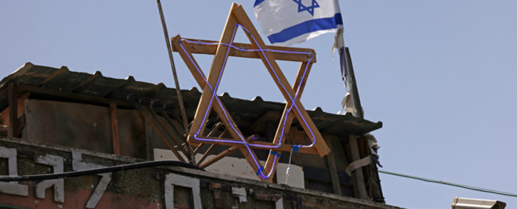 FILE: The Star of David and an Israeli flag are seen on top of a house in the Sheikh Jarrah neighbourhood of occupied east Jerusalem on 5 May 2021. Israeli Jews backed by courts have taken over houses in Sheikh Jarrah in east Jerusalem on the grounds that Jewish families lived there before fleeing in Israel's 1948 war for independence. Picture: Emmanuel DUNAND/AFP