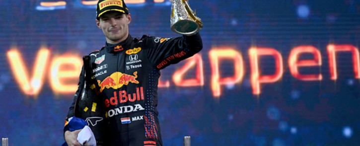 2021 FIA Formula One World Champion Red Bull's Dutch driver Max Verstappen celebrates on the podium of the Yas Marina Circuit after the Abu Dhabi Formula One Grand Prix on 12 December 2021. Picture: ANDREJ ISAKOVIC/AFP